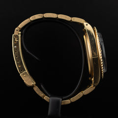 Profil latéral gauche de la Rolex Submariner en or jaune soulignant la carrure lisse et les maillons massifs du bracelet