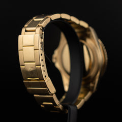 Vue arrière de la Rolex Submariner or jaune sur socle, fond de boîtier visible, bracelet Oyster incurvé et fermoir fermé