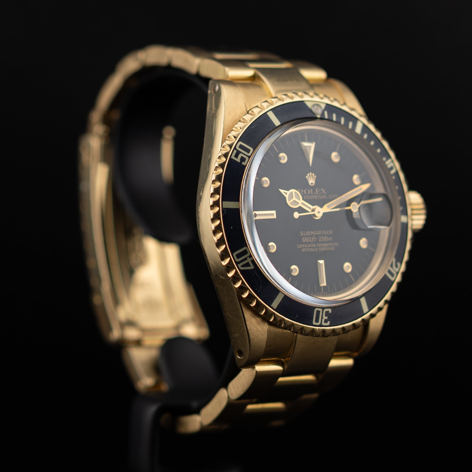 Rolex Submariner or jaune vue oblique basse mettant en valeur les cornes brossées du boîtier et le bracelet trois maillons