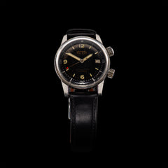 Montre Verbel Superwaterproof de 1959 vue de face, cadran noir patiné au tritium, deux couronnes d'origine, boîtier acier 36 mm