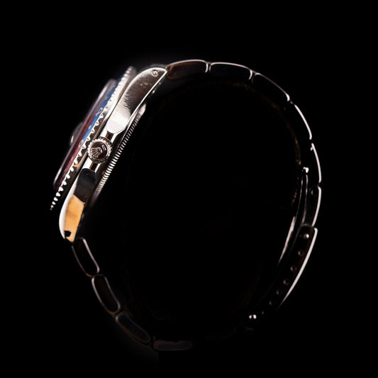 Vue de profil montre Rolex GMT-Master Pepsi avec boîtier acier et couronne signée